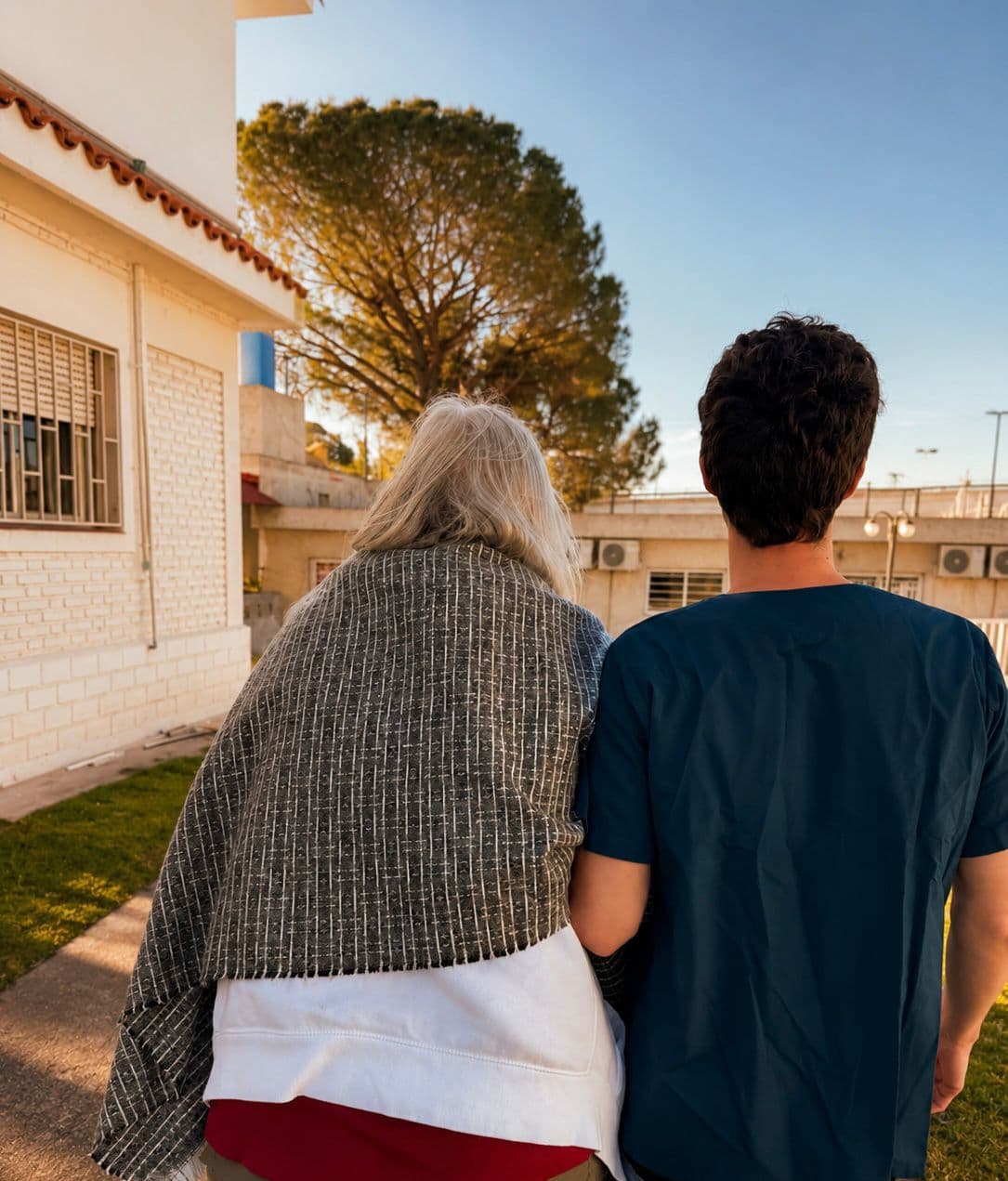Un integrante del equipo acompaña a una residente durante un paseo por el exterior